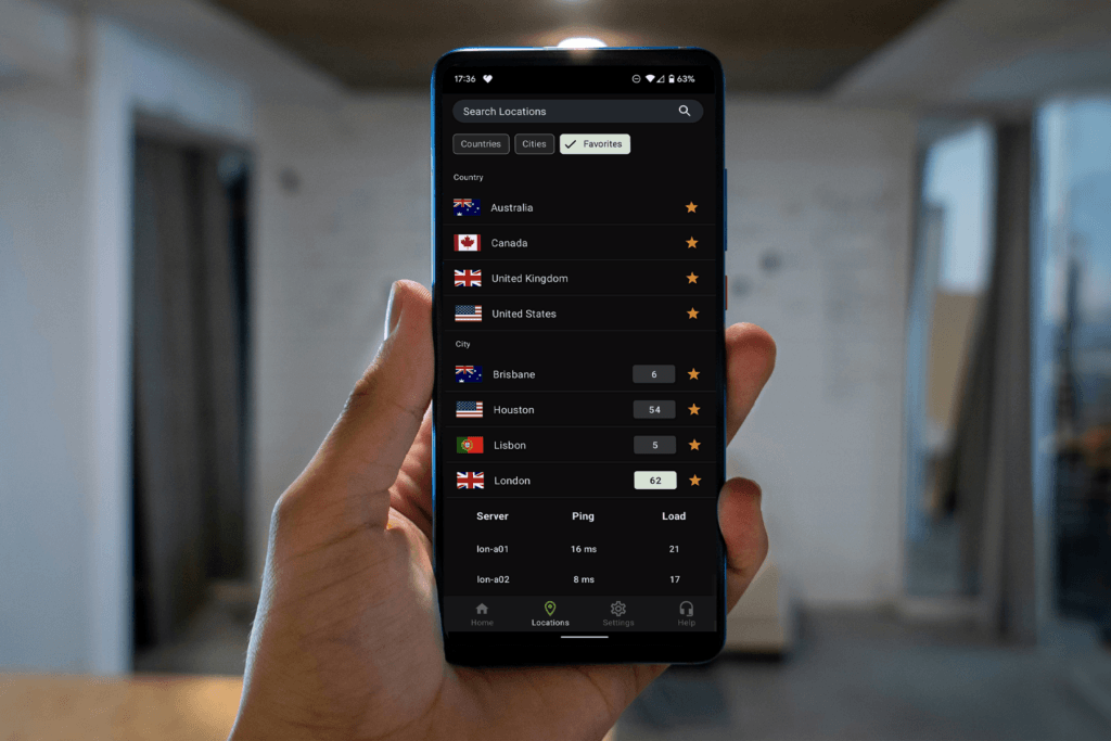 A person holds a phone open to the IPVanish app displaying the list of server locations to change your VPN location with